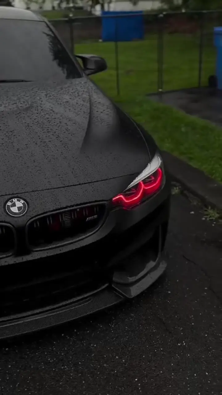 BMW M4 Black Sports Car with Red Headlights in Rain