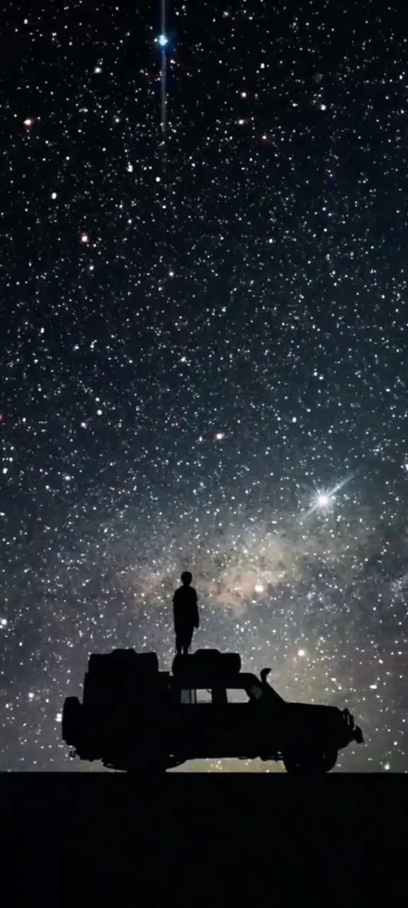 Stargazer Silhouette and Car Under Starry Night Sky