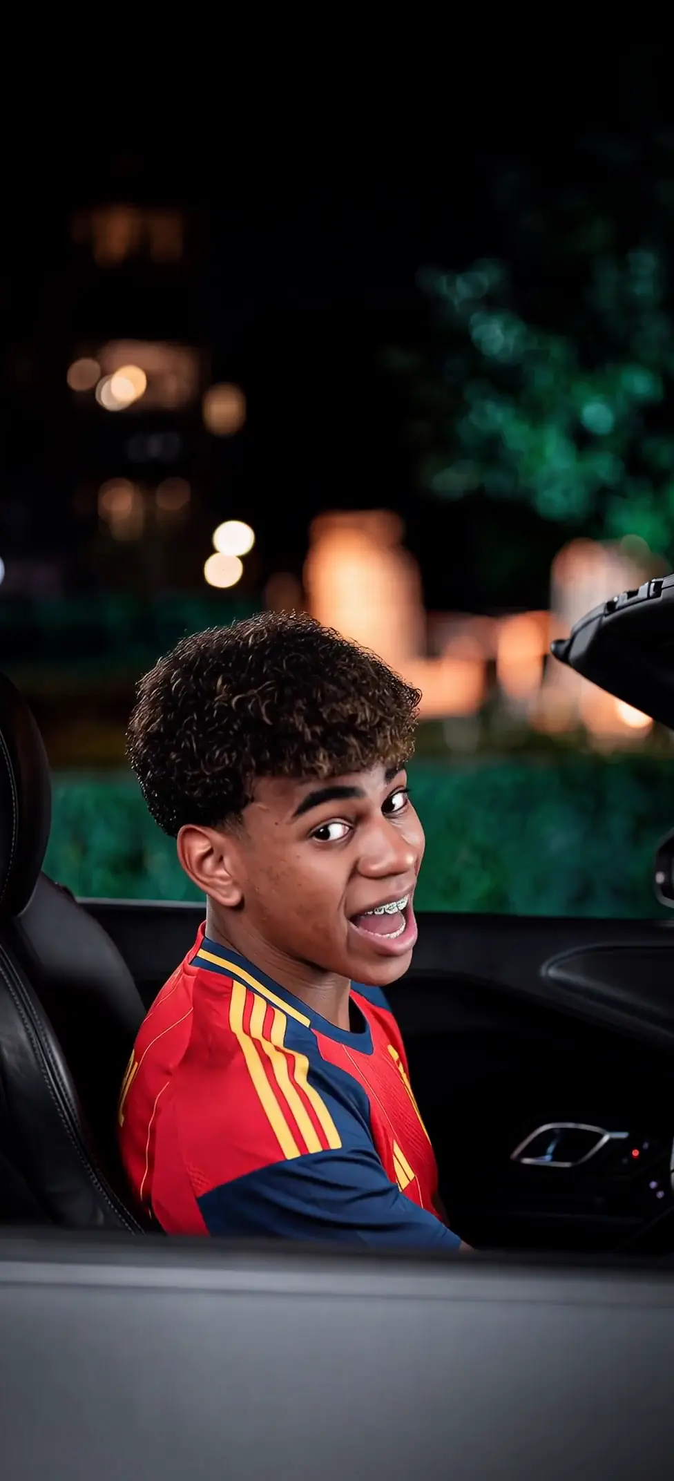 Young Man Winking in Car Night Drive 4K Wallpaper